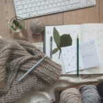 black pencil on white card beside brown knit textile