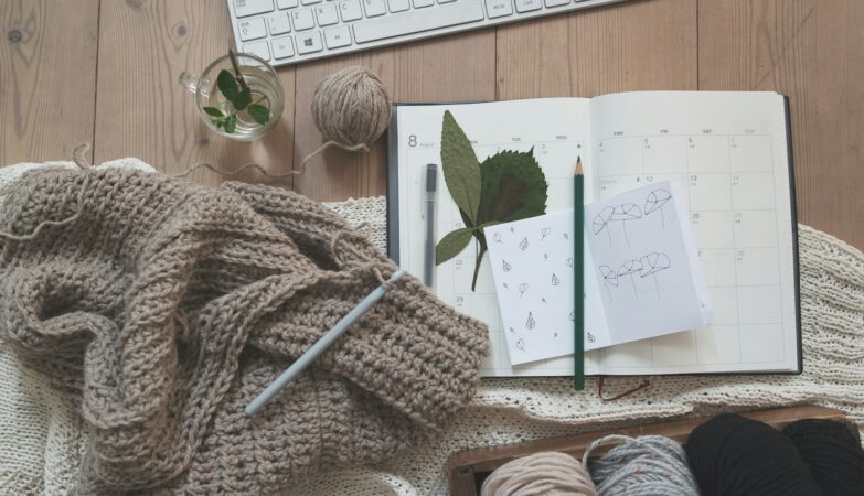 black pencil on white card beside brown knit textile