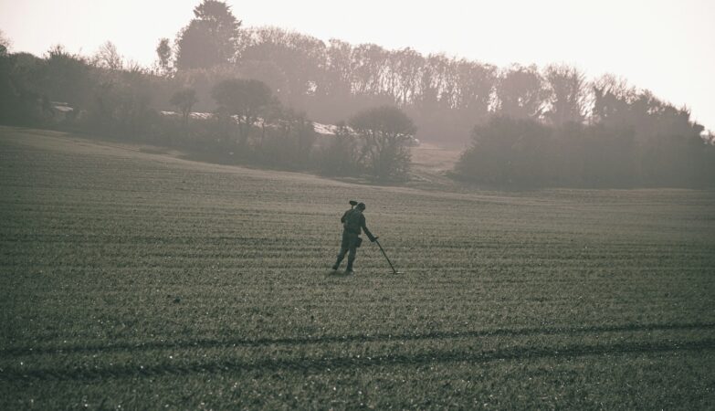 man in black jacket walking on green grass field during daytime